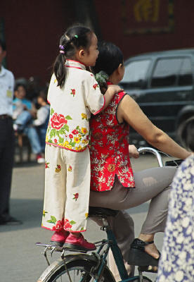 Picture:  A mother doubles her daughter on a bicycle in China.  No helmets in use.